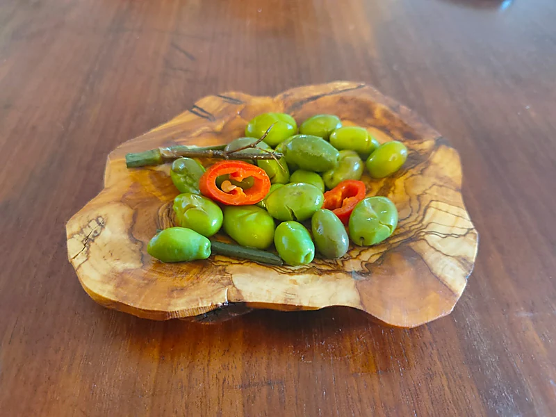 Olives with chili on olive-wood board